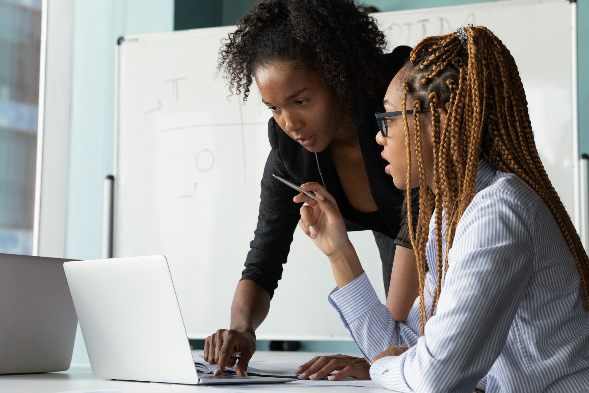 Black woman teacher stand by student desk help in work